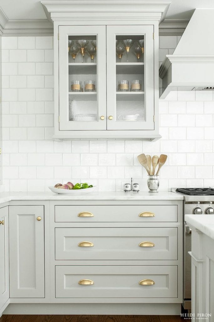 grey and gold kitchen subway tile glass cabinets brass hardware