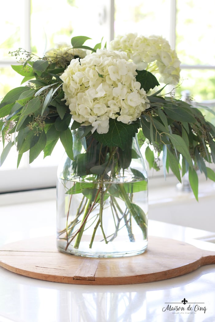  hortensias blancs sur une planche à pain française dans une cuisine de campagne française blanche