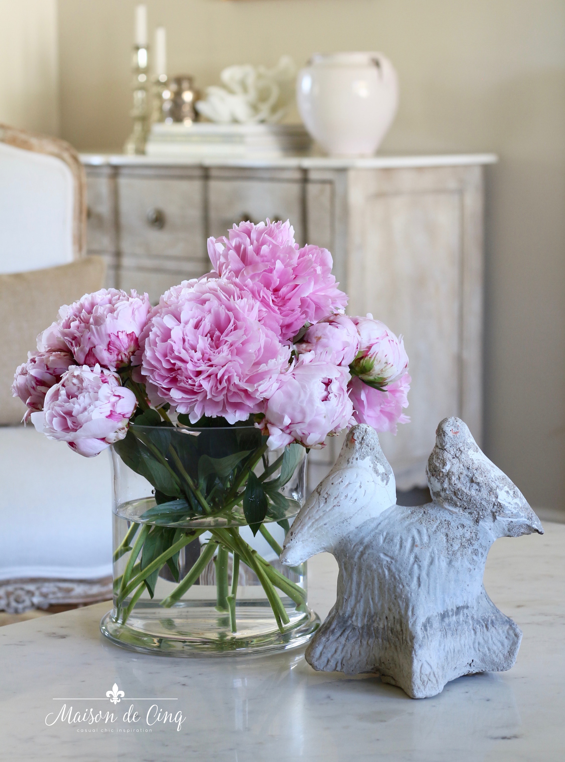 pink peonies in glass vase on coffee table in French country living room 