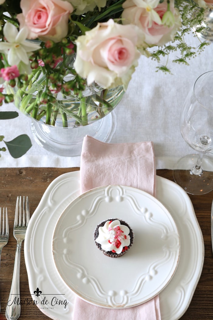 white plates with pink napkin and pink roses Valentine's day table setting