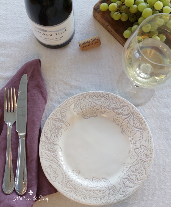 place setting with patterned plate and plum linen napkin
