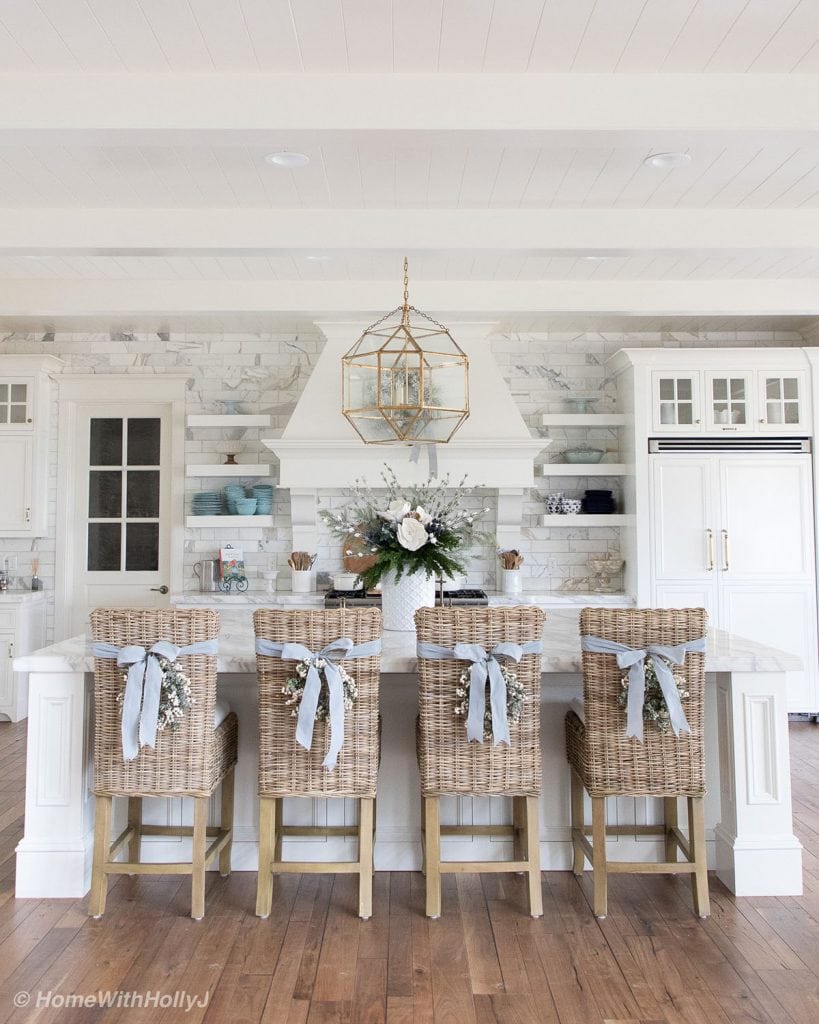 stunning white French country kitchen wicker chairs gold chandelier open shelves marble tile
