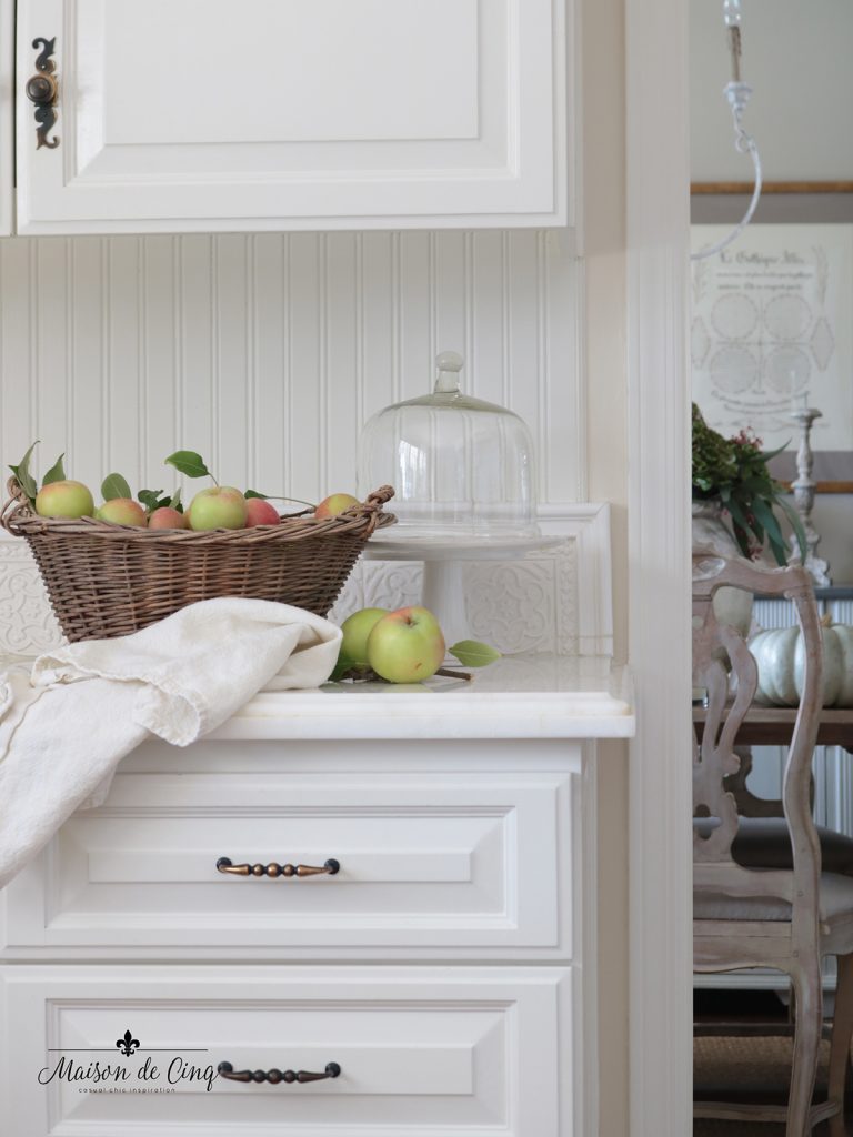 fall decorating ideas in white farmhouse kitchen apples in vintage basket and cake stand 