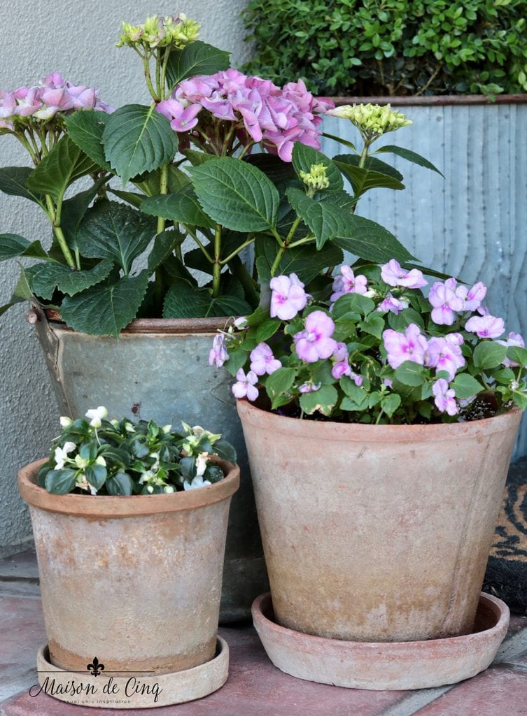 pots of impatiens and hydrangeas in pink and white pretty spring front porch decor 