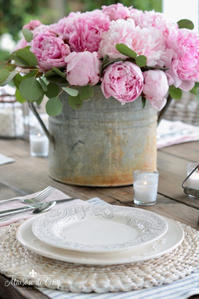 spring table decor peonies with blue and white placemats candles and seagrass chargers 