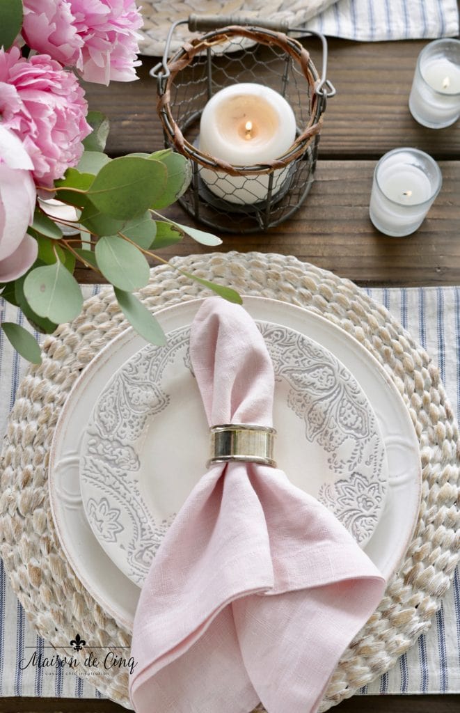 gorgeous spring table decor idea pink napkin blue and white plates seagrass charger and candles 