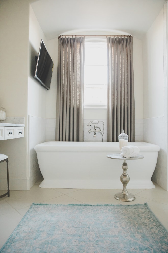 French country master bathroom with free standing tub and blue rug