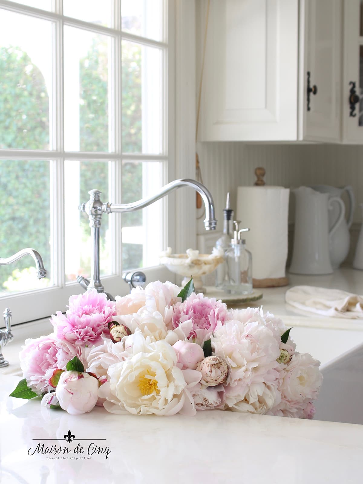 gorgeous pink and white peonies in sink in white kitchen 
