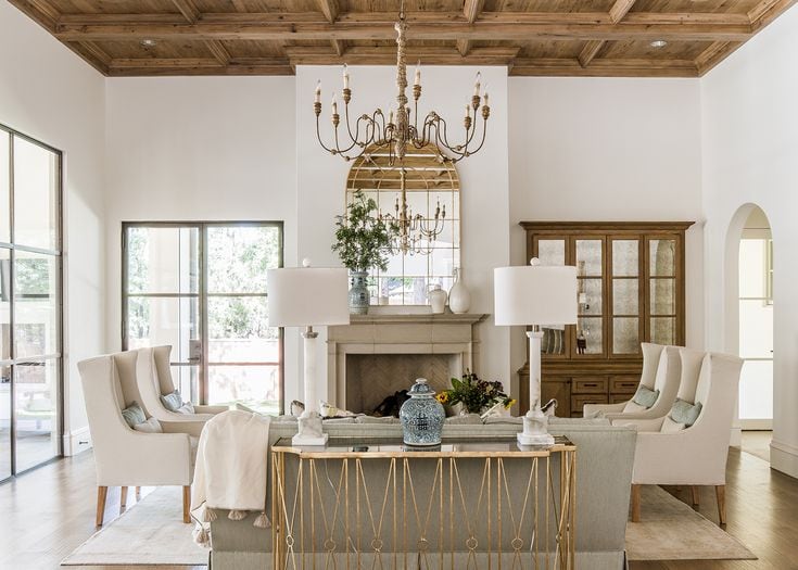 gorgeous European style living room with wood ceiling and neutral furniture white walls 