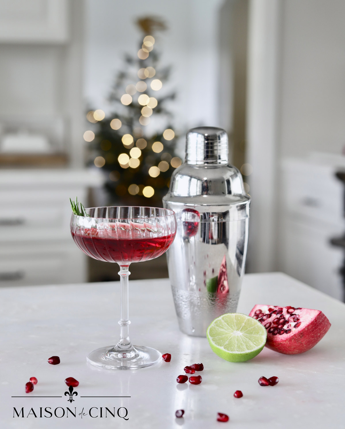 cocktail shaker with red pomegranante cocktail on counter in white kitchen christmas holiday cocktail ideas 