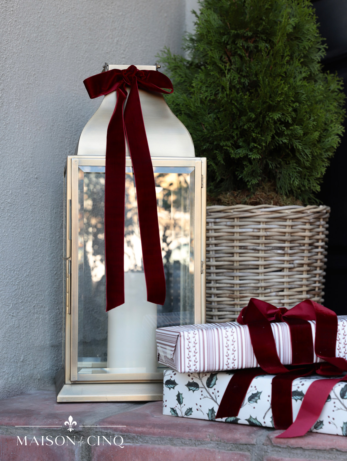 gorgeous brass lantern with burgundy ribbon and gifts decorating christmas porch 