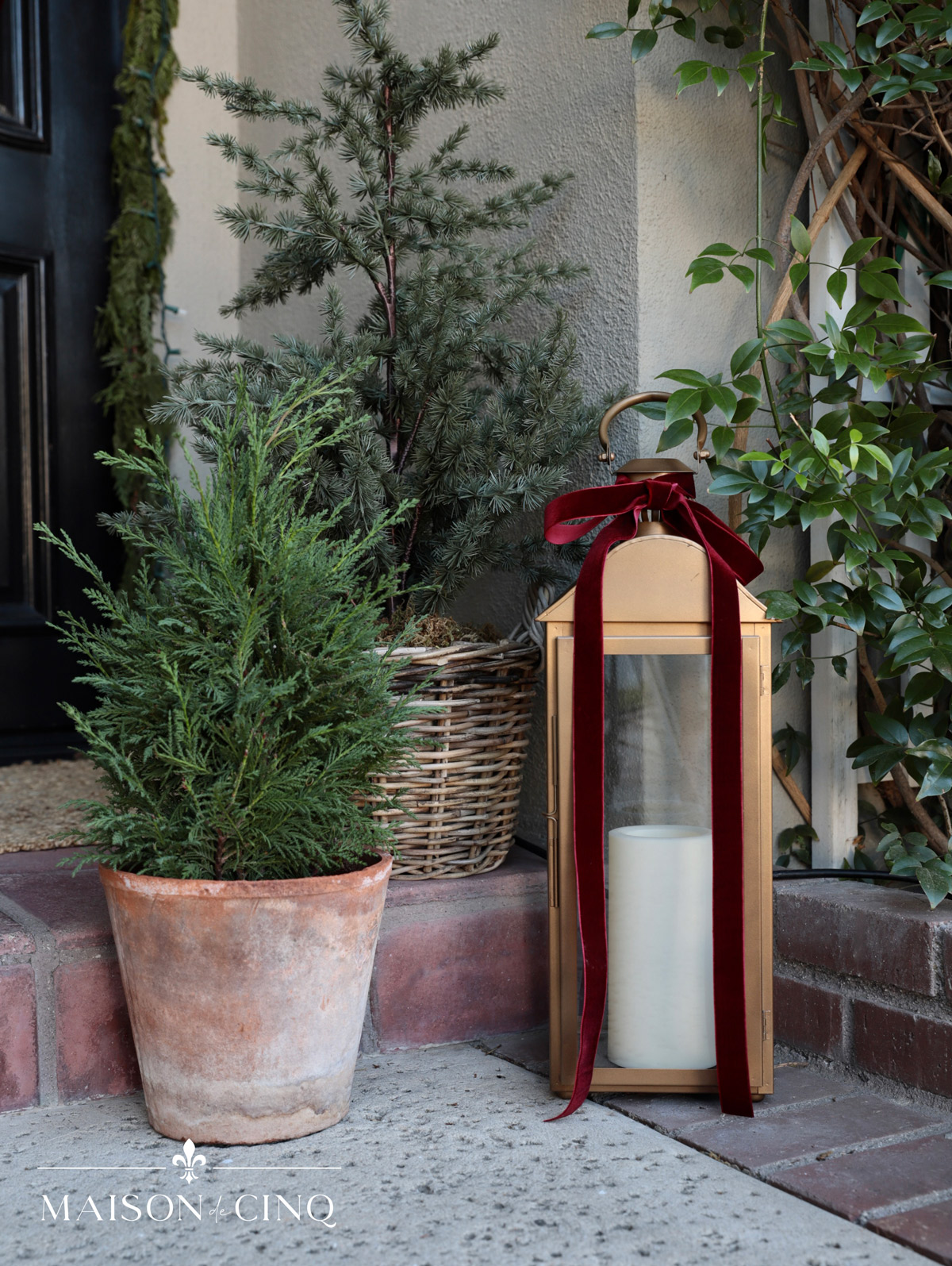brass lanterns and pine trees on holiday porch christmas decor ideas 
