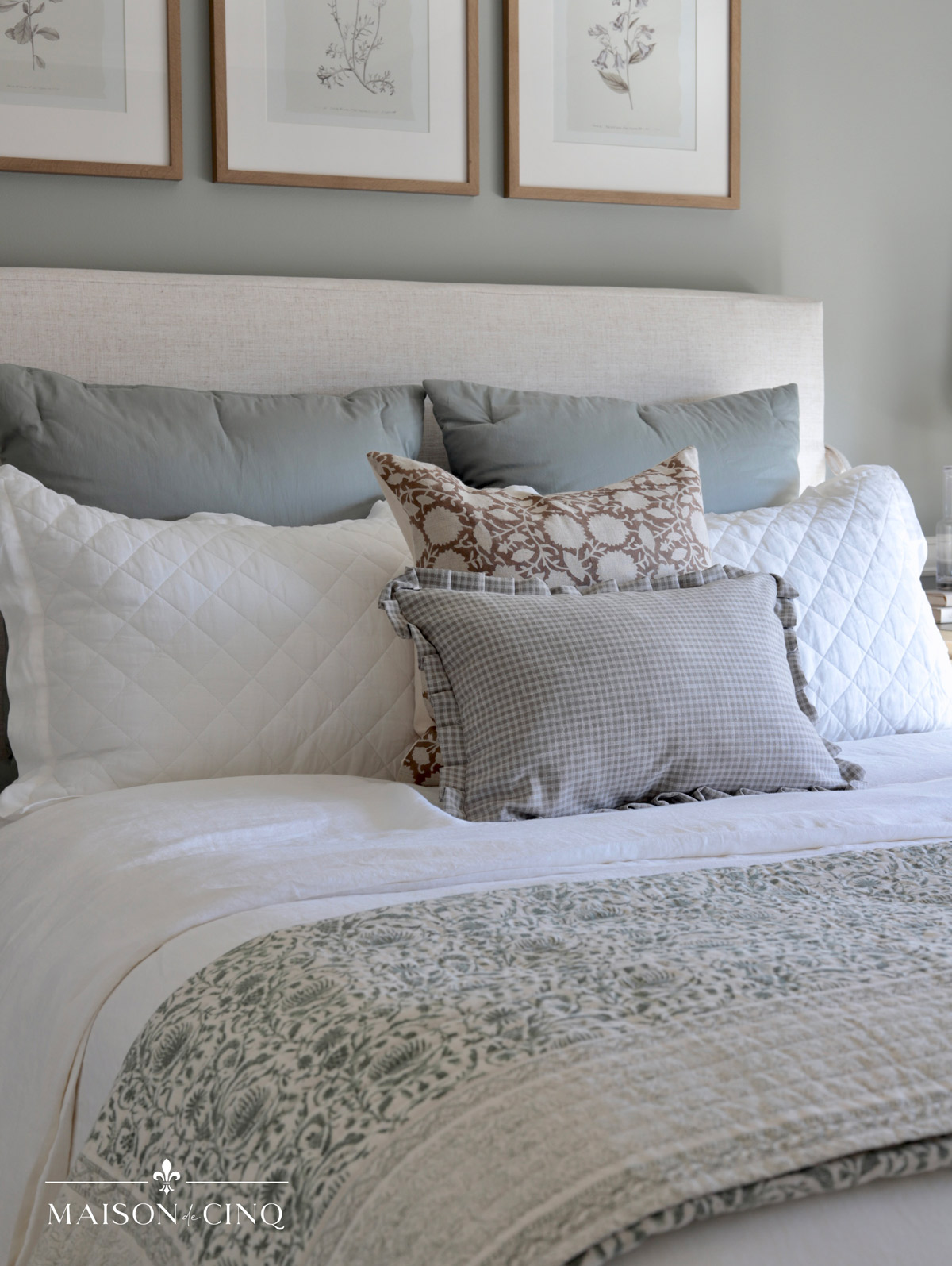beautiful bedding of white linen shams and pretty floral patterned pillows 