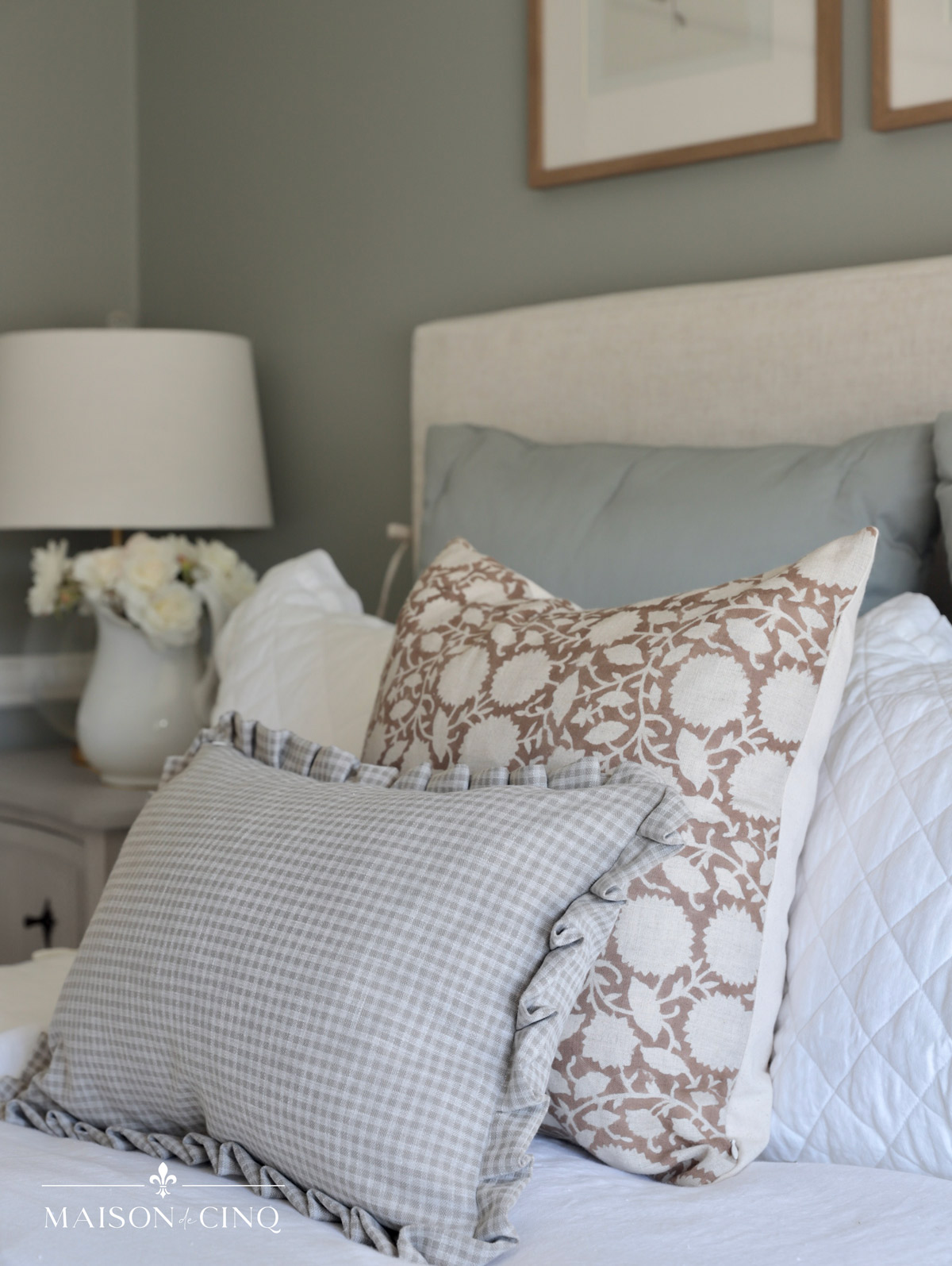 pretty pattern pillows on upholstered bed in green/blue french bedroom 