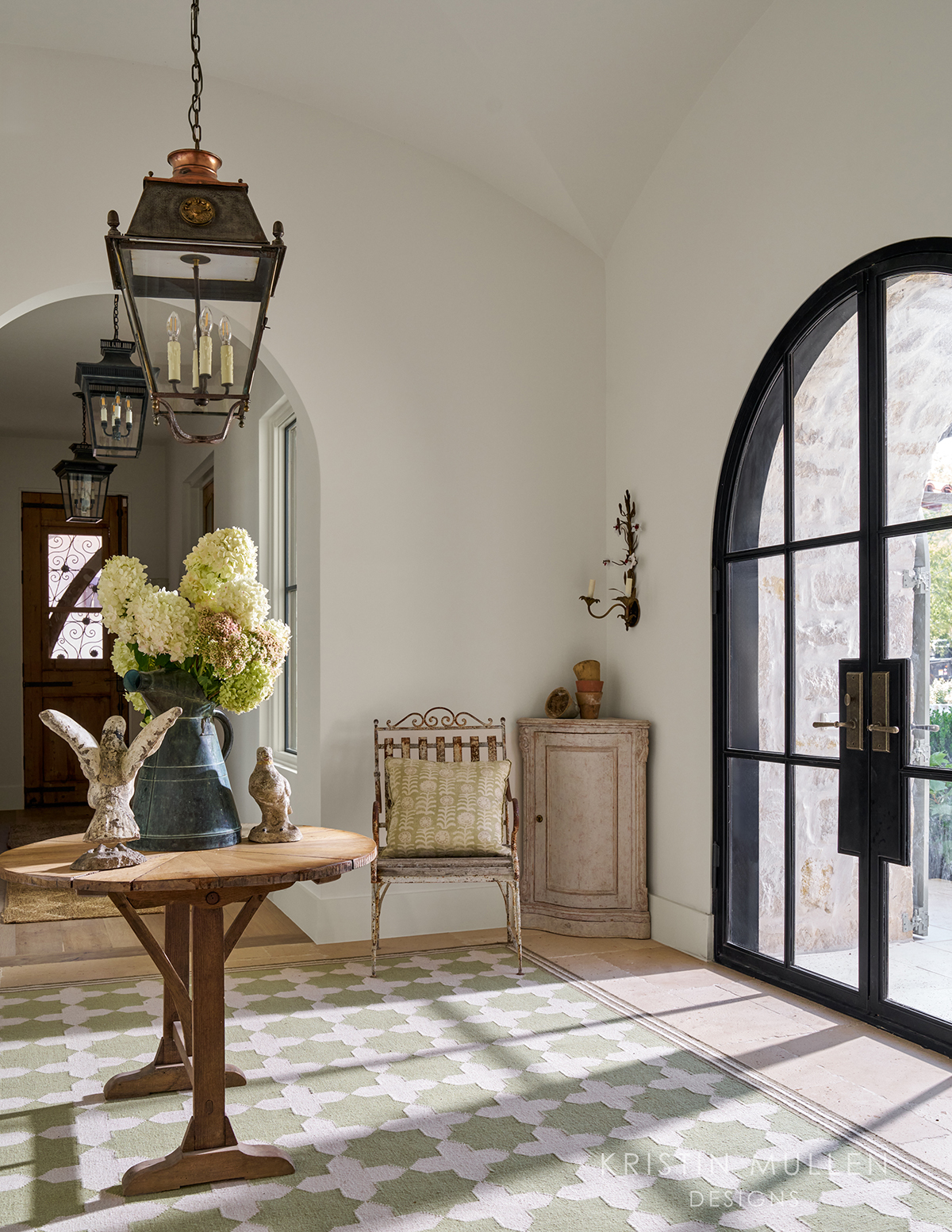 European style home gorgeous entry way with antiques and black iron doors 