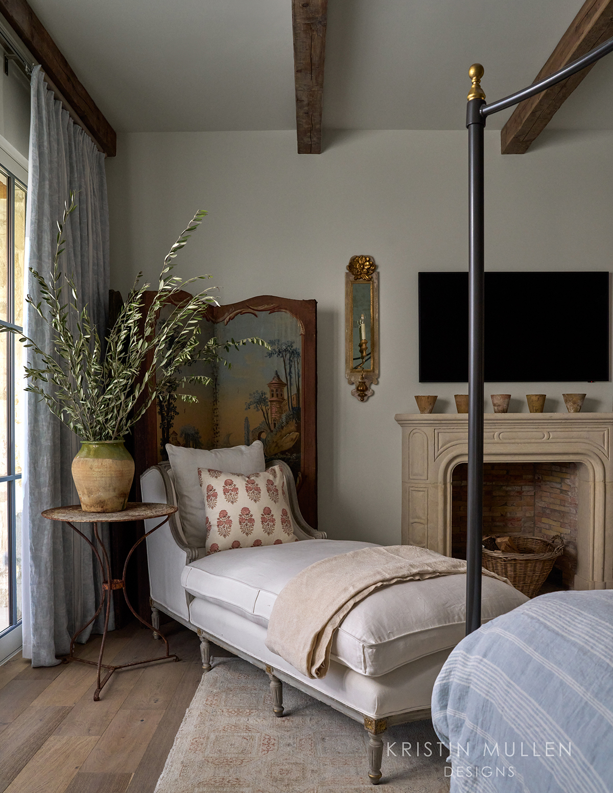 chaise lounge in European inspired primary bedroom 
