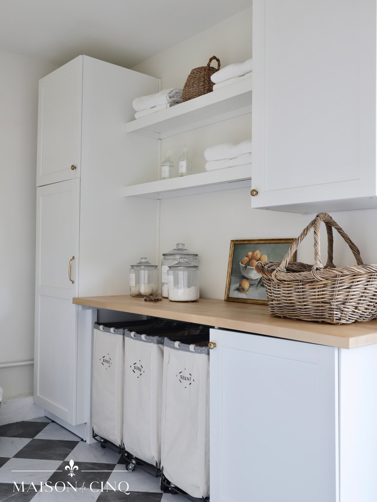 Ikea shelves create a gorgeous laundry area in garage with white shelves and butcher block counter