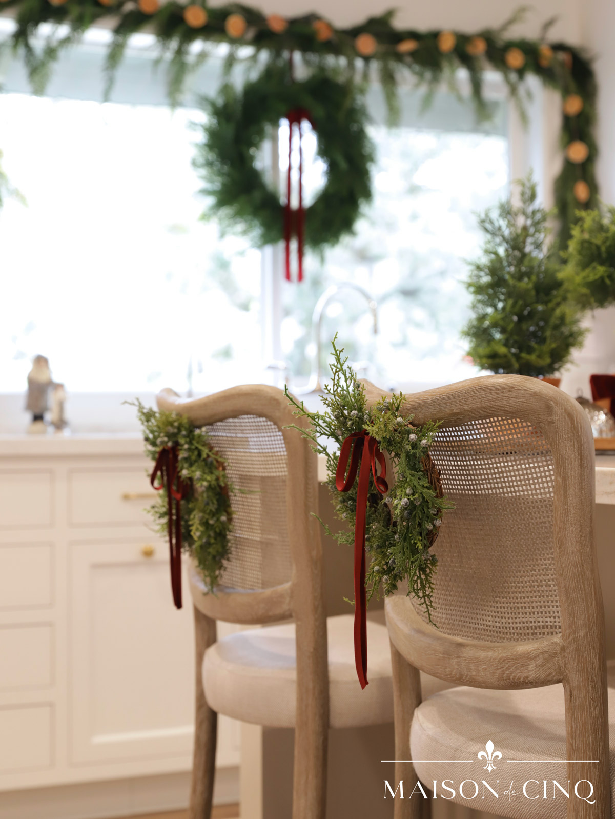 wreaths on backs of counter stools island in French country kitchen christmas decor 