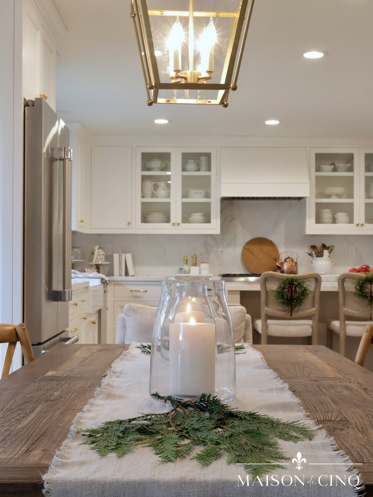 dining table with hurricanes and greenery Christmas decorating holiday decor ideas 
