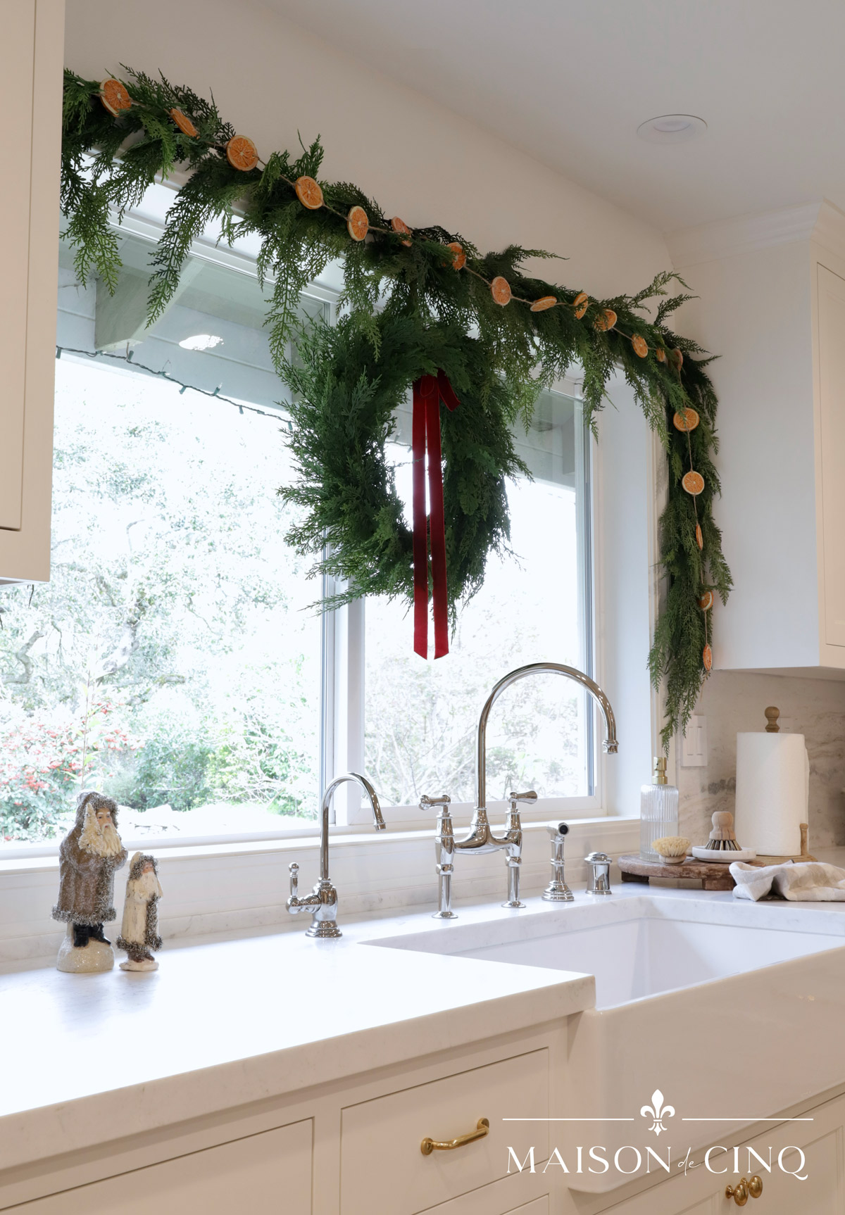 wreath and dried orange garland around the kitchen window gorgeous christmas decorating 