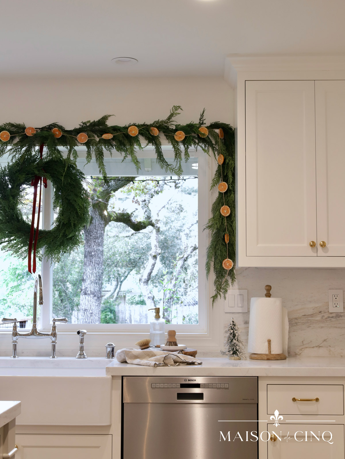 european-inspired christmas tour gorgeous holiday decor in the kitchen with dried orange garland around the winow
