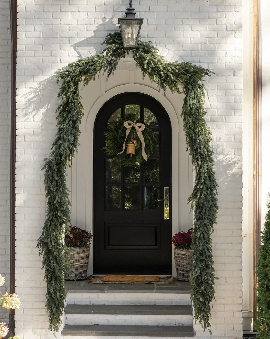 stunning Christmas porch with black door and dramatic garland
