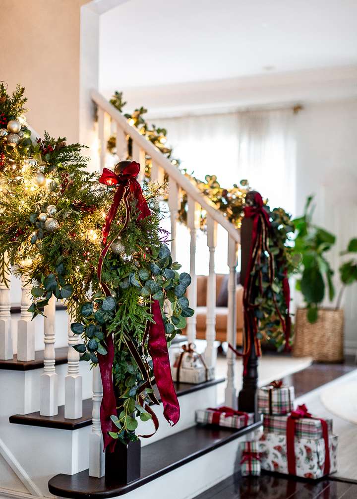Classic Christmas Decor: 20 Stunning Ideas to Inspire stunning garland on stairwell with red ribbon classic christmas decorating ideas