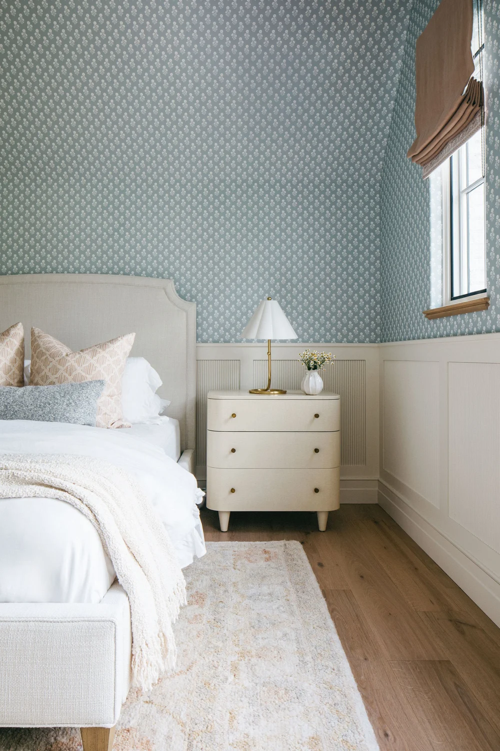 pretty bedroom with wallpaper floral rug and upholstered headboard 